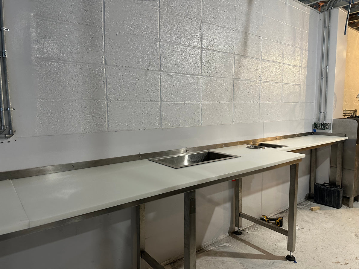 Mid construction (60 days in) The stainless steel support legs arrived from fabricator. Here  we see the 1" plastic counter tops Installed.