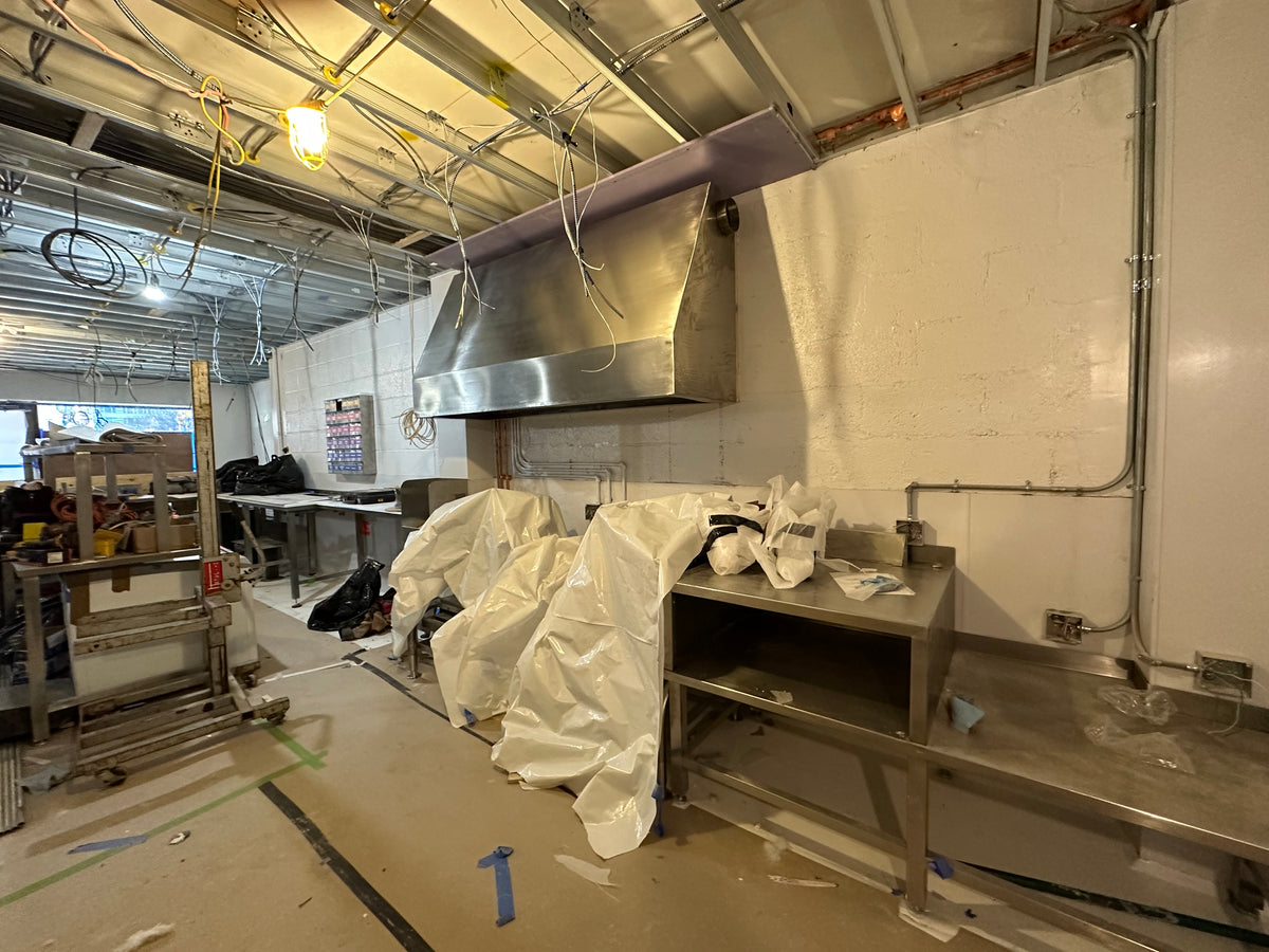 The hood never vented. It’s there for looks, and now it catches a bit of steam from the soup kettles. I built the table on the right for a 6-gallon blender we never ended up using.